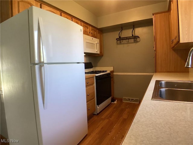 9083 Priem Rd, Strongsville, OH 44149 - kitchen featuring light countertops, visible vents, a sink, white appliances, and dark wood-style flooring