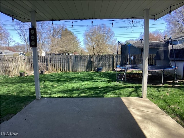 9083 Priem Rd, Strongsville, OH 44149 - view of yard featuring a patio area, a fenced backyard, and a trampoline