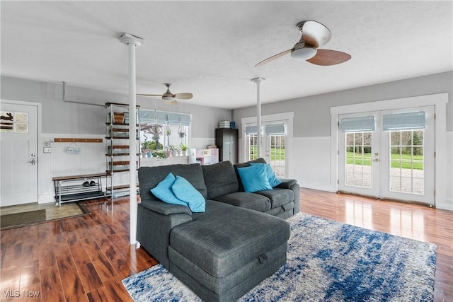 living area featuring a ceiling fan, wood finished floors, a wealth of natural light, and a textured ceiling