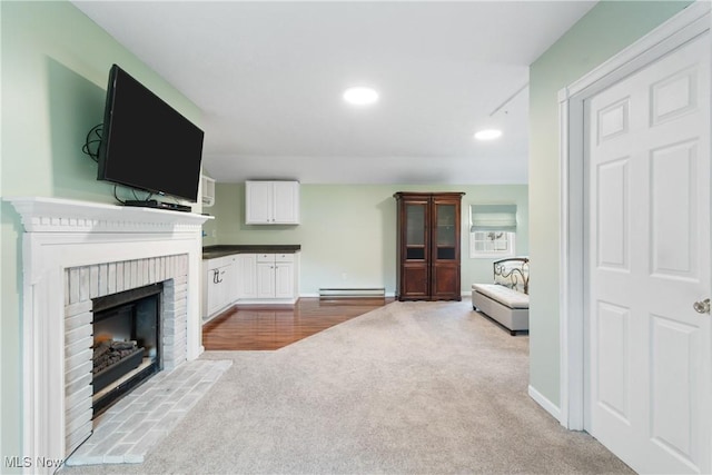 living room with a baseboard radiator, carpet, a fireplace, and baseboards