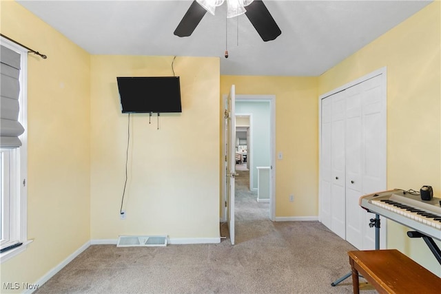 carpeted bedroom featuring baseboards, a ceiling fan, visible vents, and a closet