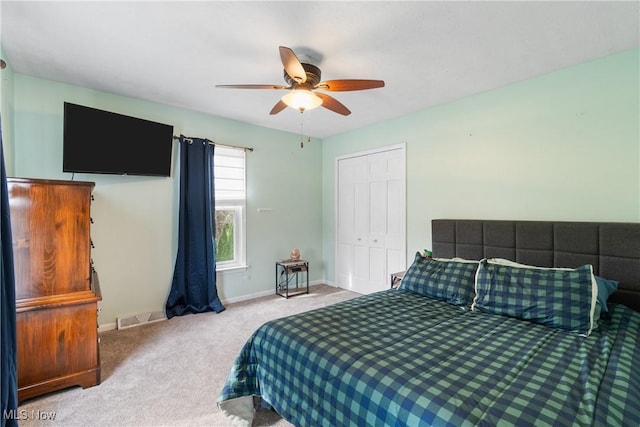 carpeted bedroom featuring a closet, visible vents, a ceiling fan, and baseboards