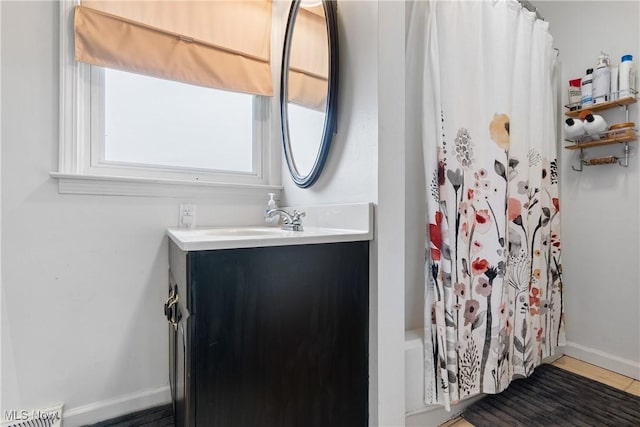 bathroom featuring a shower with shower curtain, baseboards, visible vents, and vanity
