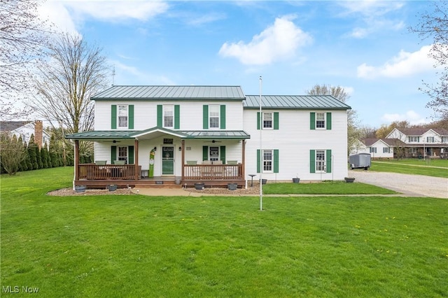 rear view of house featuring a porch, a standing seam roof, a ceiling fan, and a yard