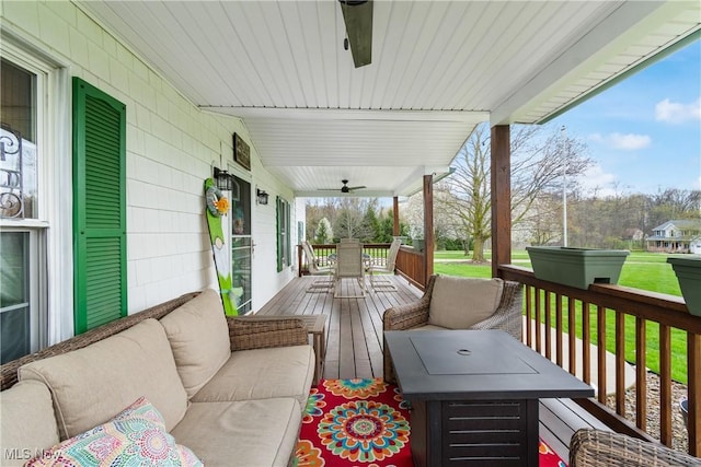 wooden terrace featuring an outdoor living space, ceiling fan, covered porch, and outdoor dining space