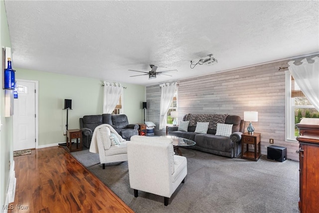 living area with wood finished floors, a textured ceiling, and ceiling fan