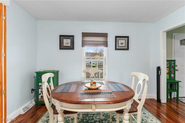 dining space with visible vents, baseboards, and dark wood finished floors