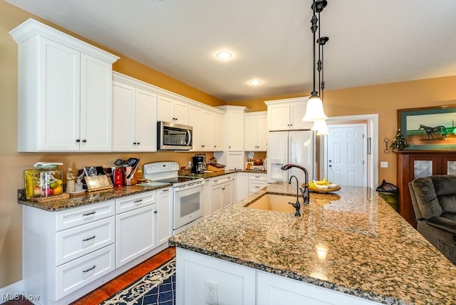 kitchen with white cabinets, a sink, and white appliances