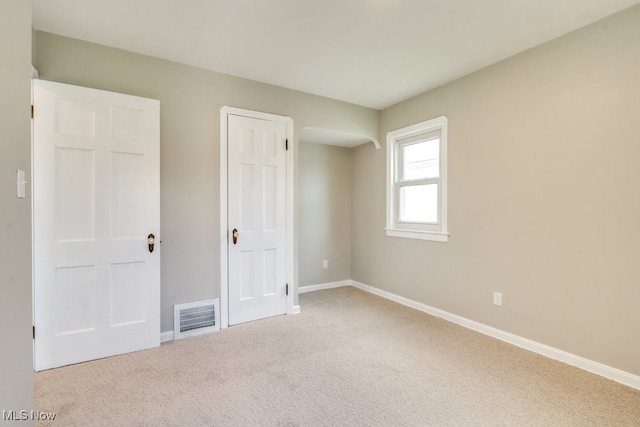 unfurnished bedroom with baseboards, visible vents, and carpet