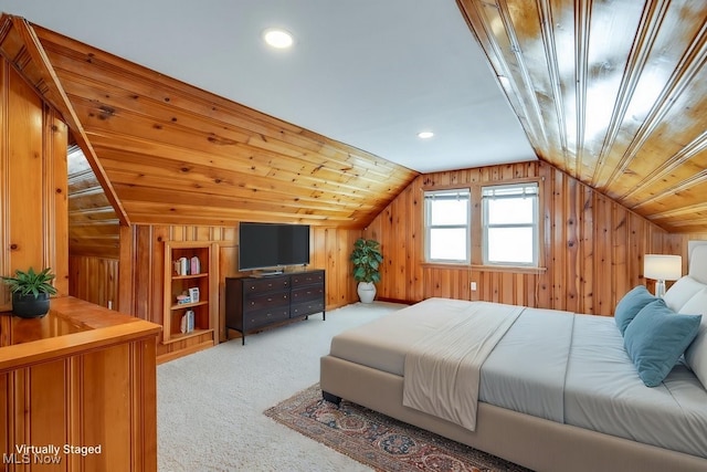 bedroom with light colored carpet, vaulted ceiling, and wooden walls