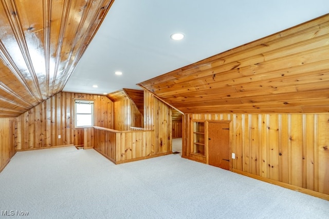 additional living space featuring recessed lighting, vaulted ceiling, carpet floors, and wood walls