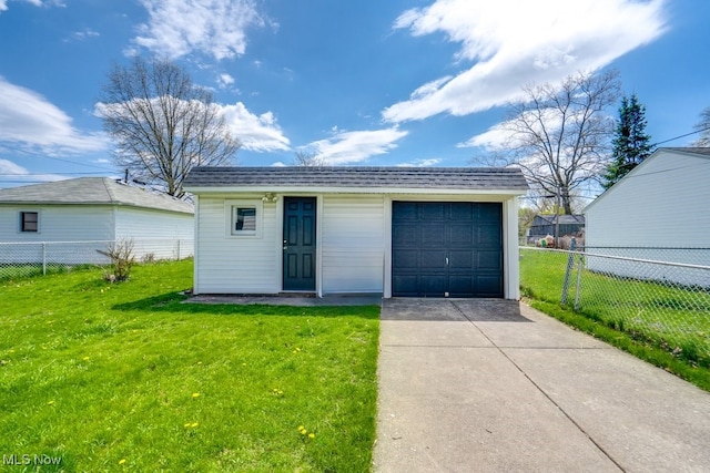 garage featuring fence and concrete driveway