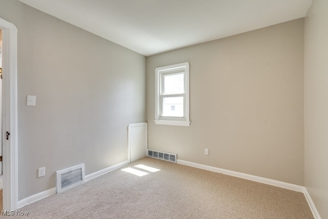 spare room featuring carpet and visible vents