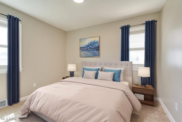 bedroom featuring light colored carpet, baseboards, and visible vents