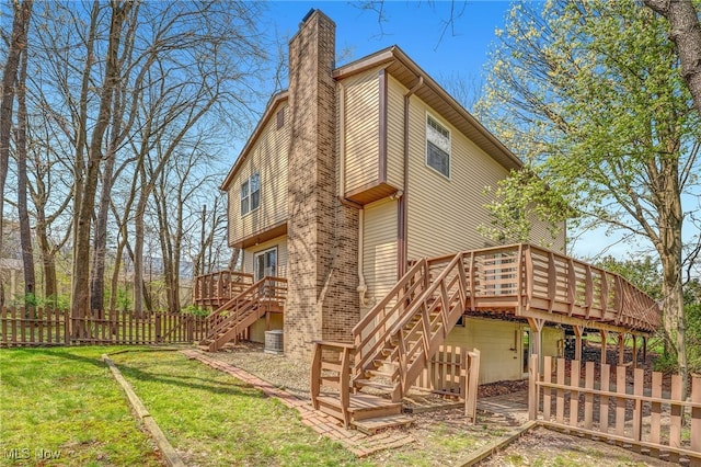 back of property featuring stairway, a wooden deck, a chimney, and fence