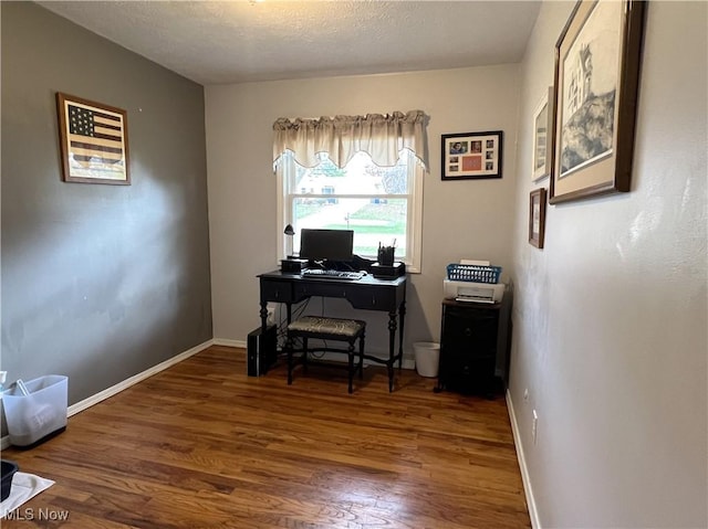 office space with baseboards, wood finished floors, and a textured ceiling