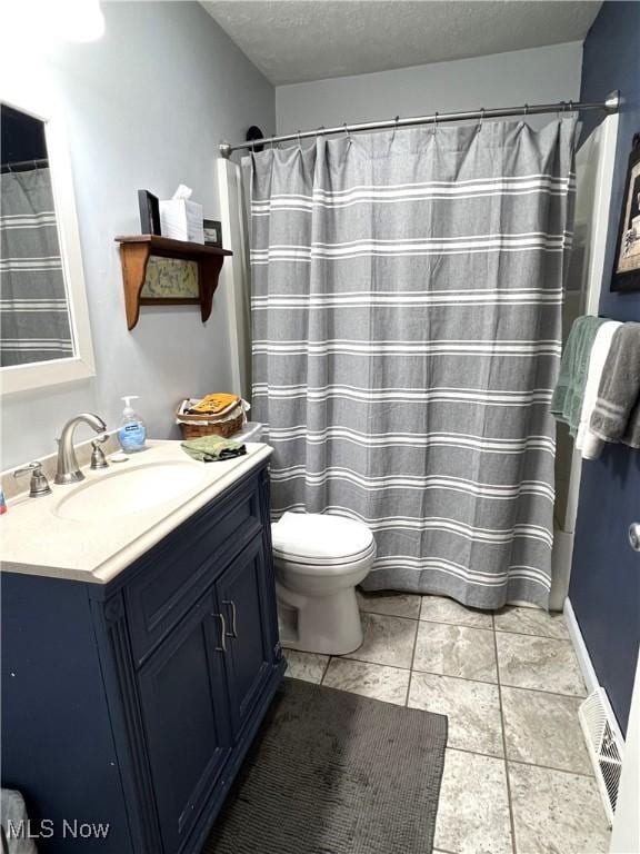 full bathroom featuring a textured ceiling, toilet, vanity, and tile patterned floors