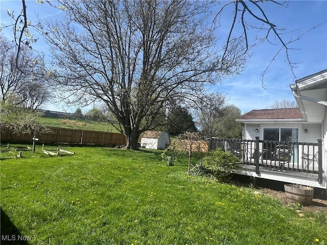 view of yard featuring a wooden deck and fence