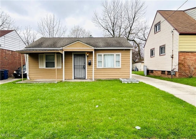 bungalow-style house with a shingled roof and a front yard