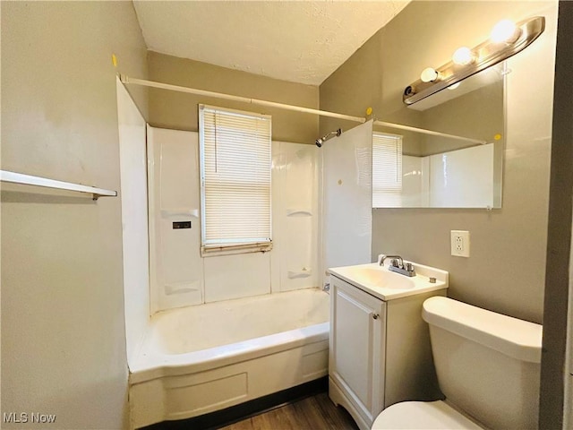 bathroom with toilet, vanity, wood finished floors, and shower / bathing tub combination