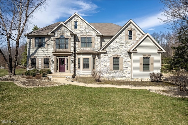 craftsman-style home featuring stone siding and a front yard