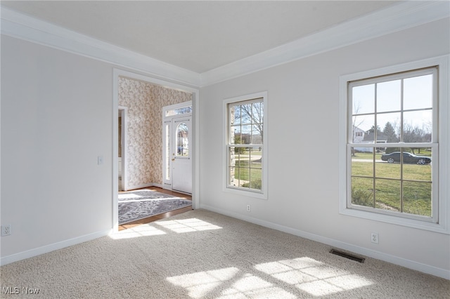 unfurnished room featuring baseboards, visible vents, carpet flooring, and crown molding