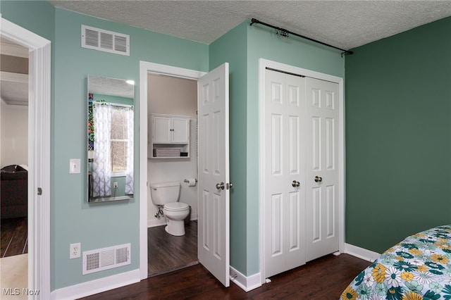 bedroom with a closet, visible vents, and dark wood-style floors