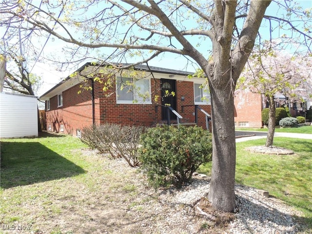 view of front of property featuring brick siding and a front yard
