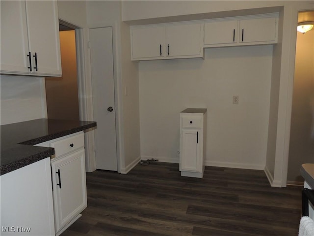 clothes washing area featuring baseboards and dark wood-style floors