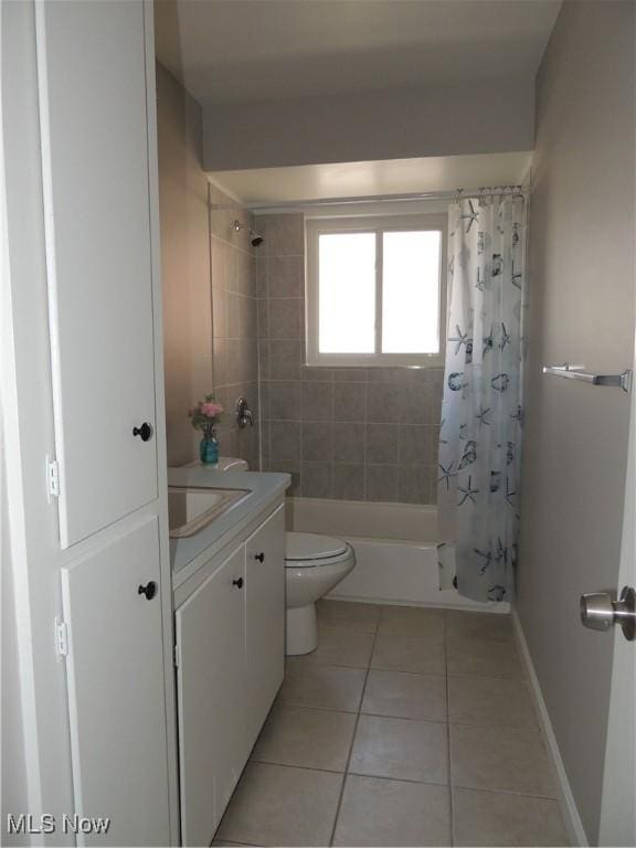 bathroom featuring tile patterned floors, toilet, vanity, baseboards, and shower / bath combo