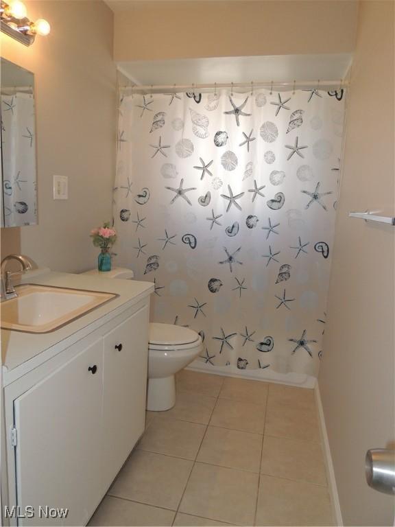 full bath featuring tile patterned flooring, toilet, a shower with curtain, and vanity