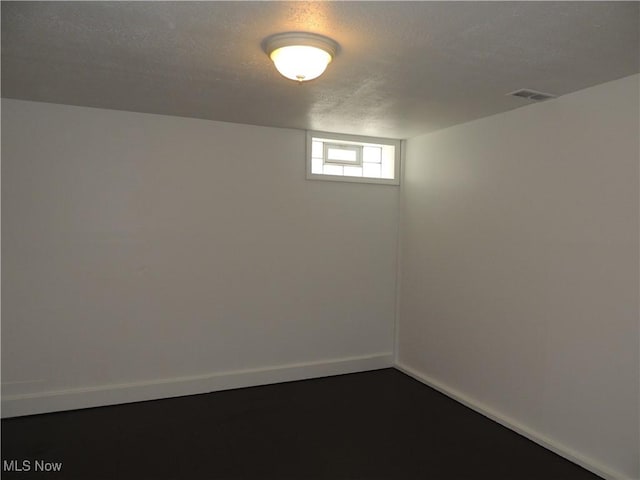 basement featuring visible vents and baseboards