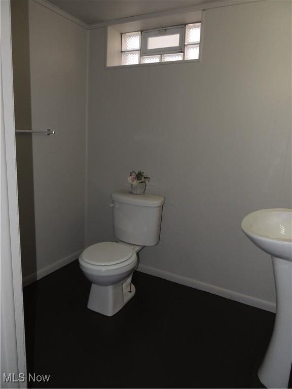 half bathroom with toilet and baseboards