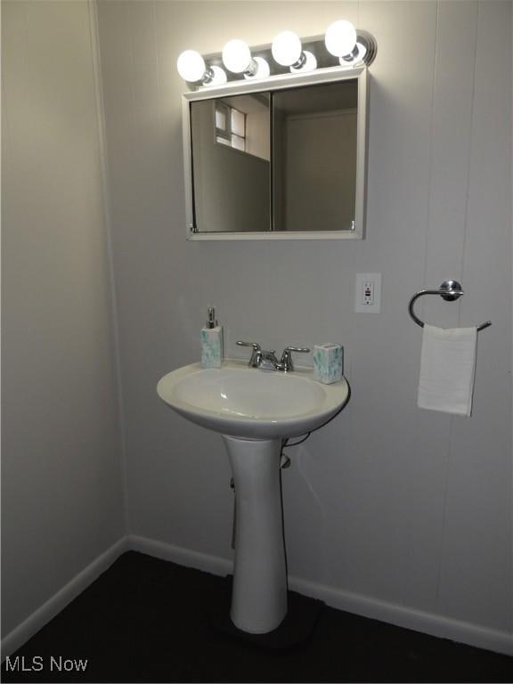 bathroom featuring baseboards and a sink