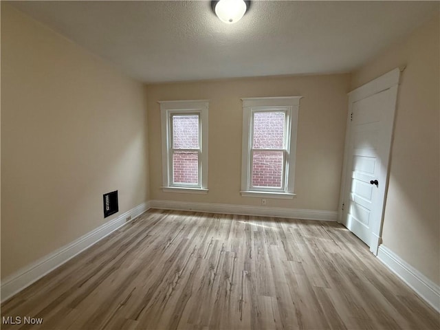807 Virginia Ave, Follansbee, WV 26037 - empty room featuring light wood-style flooring, baseboards, and a textured ceiling