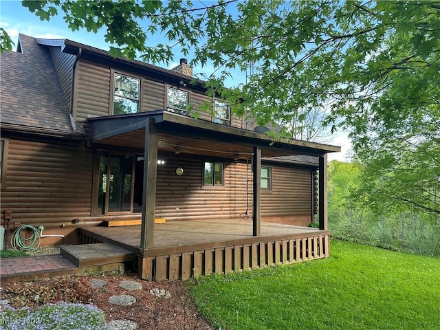 view of side of home featuring roof with shingles, faux log siding, a chimney, and a yard