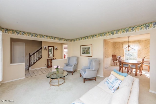 living area featuring baseboards, carpet, stairs, and an inviting chandelier