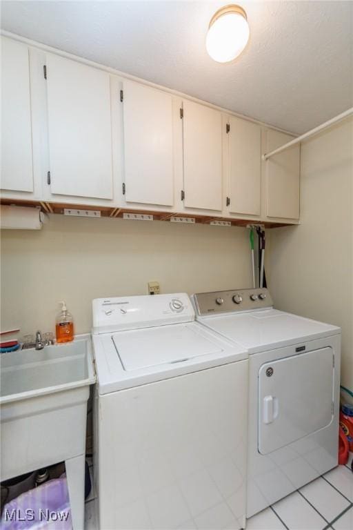 clothes washing area with washing machine and clothes dryer, a sink, and cabinet space