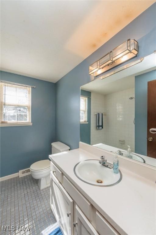 bathroom with plenty of natural light, vanity, tile patterned flooring, and toilet