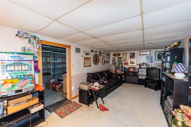 living room featuring carpet floors and a drop ceiling