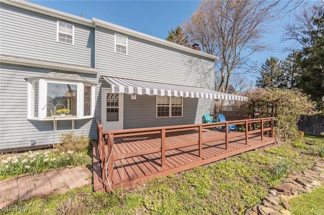 rear view of property featuring a wooden deck and a chimney