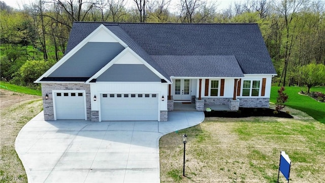 view of front of home featuring a garage, french doors, and stone siding