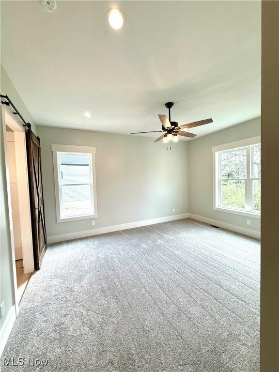 6028 Arlyne Ln, Medina, OH 44256 - carpeted empty room with baseboards, recessed lighting, ceiling fan, and a barn door