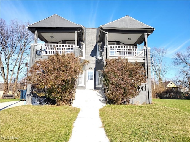 view of front of home with a front lawn and a balcony