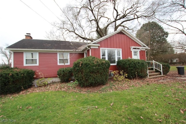 224 E Pine St, Lisbon, OH 44432 - view of front of property featuring a chimney, board and batten siding, and a front yard