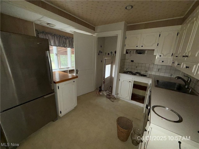 224 E Pine St, Lisbon, OH 44432 - kitchen featuring cooktop, a sink, light colored carpet, white cabinetry, and freestanding refrigerator