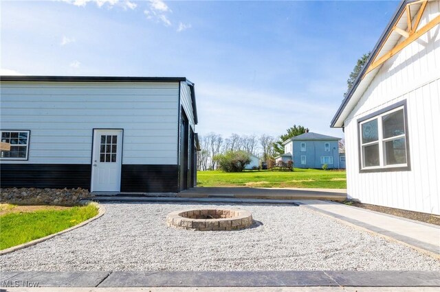 view of side of property featuring a fire pit and a yard