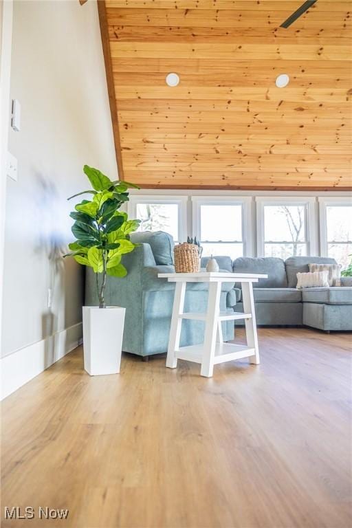 living area featuring baseboards, high vaulted ceiling, wood finished floors, and wood ceiling