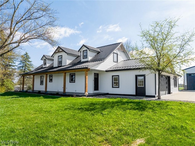 view of front facade with a garage, a front yard, a standing seam roof, and metal roof