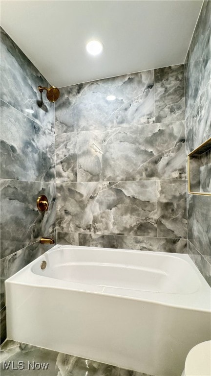 bathroom featuring tile walls, marble finish floor, shower / tub combination, and toilet